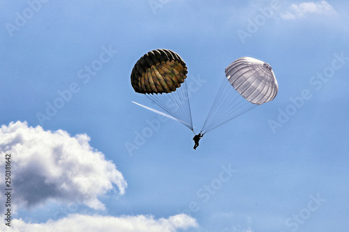 Single paratrooper with pair of vintage parachutes