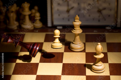 White's victory on the chessboard. The king fell.Strategy, victory, intelligence.The pawn attacks the king. Shot in motion. Flying figures.