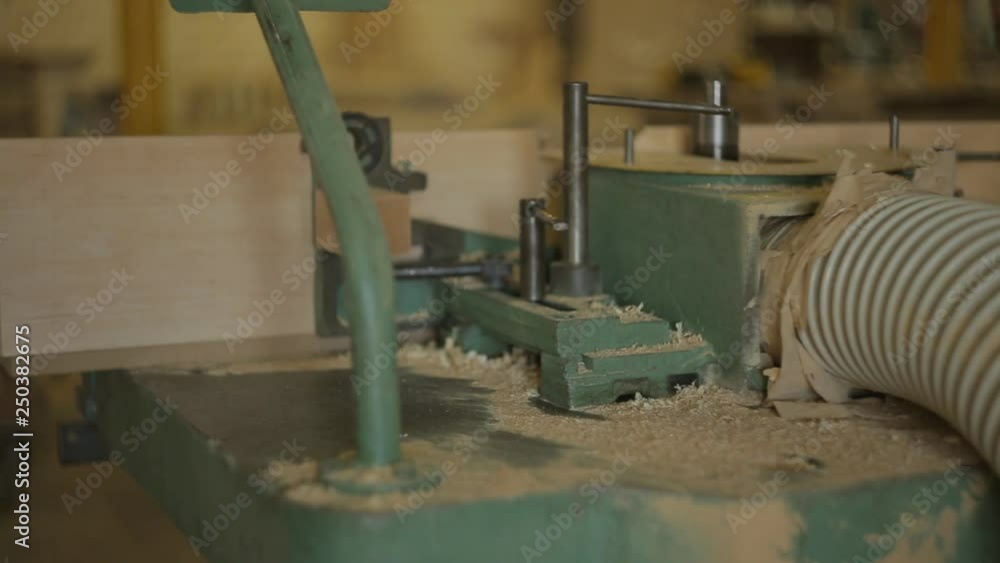 sawdust blown away from old machine for drilling round hole in the wooden plank in furniture workshop sawdust blown away from old machine for drilling round hole in the wooden plank in furniture workshop