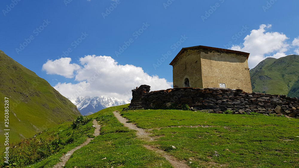 Typical landscape of Svaneti with Caucasus Mountains and the Ushguli Chapel in the village of Ushgul in Georgia