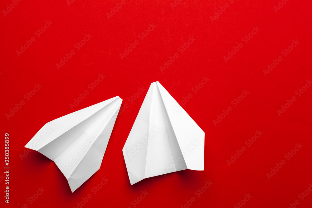 white paper airplane on a red background white paper airplane on a red background