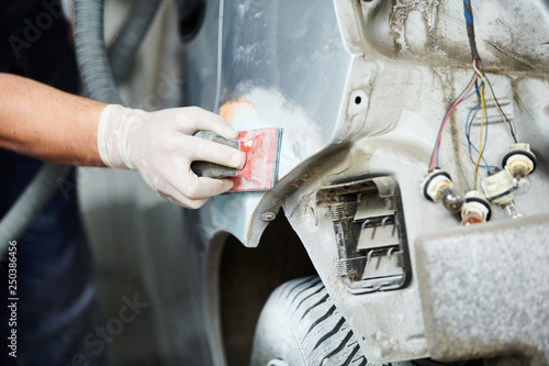 auto repairman plastering autobody bonnet