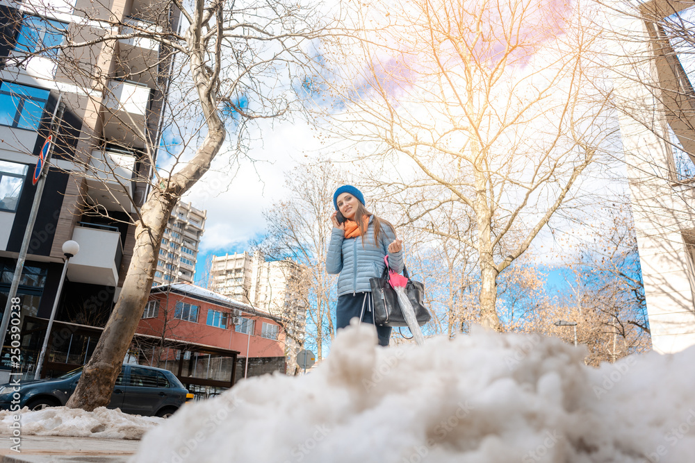 Fotografie Woman walking through melting snow in late winter