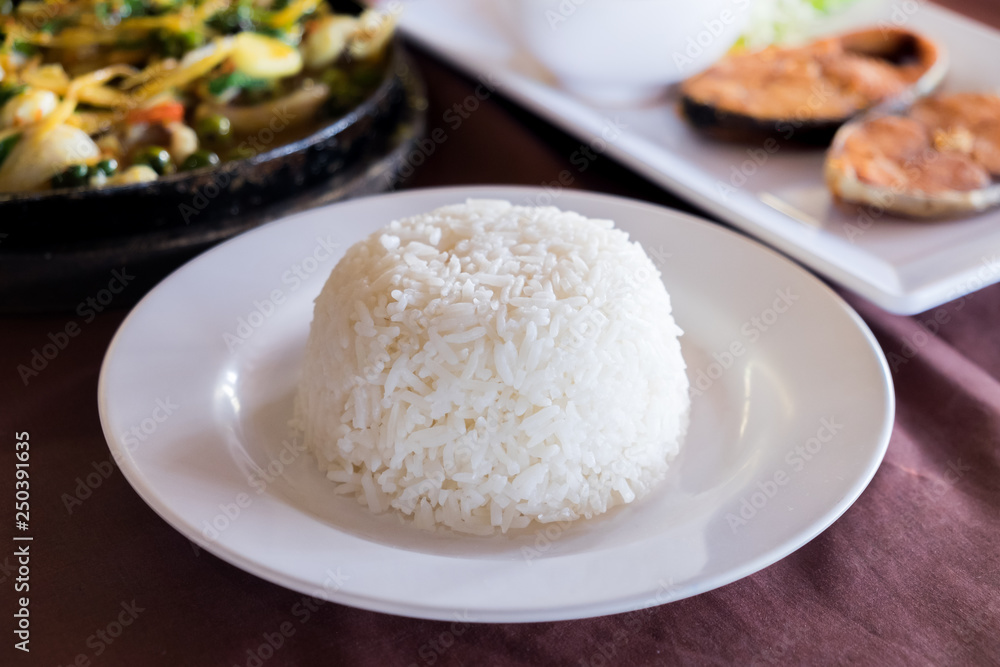 Cooked white Jasmine rice served on plate on dining table.