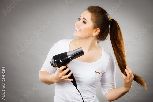 Woman drying her hair using hair dryer