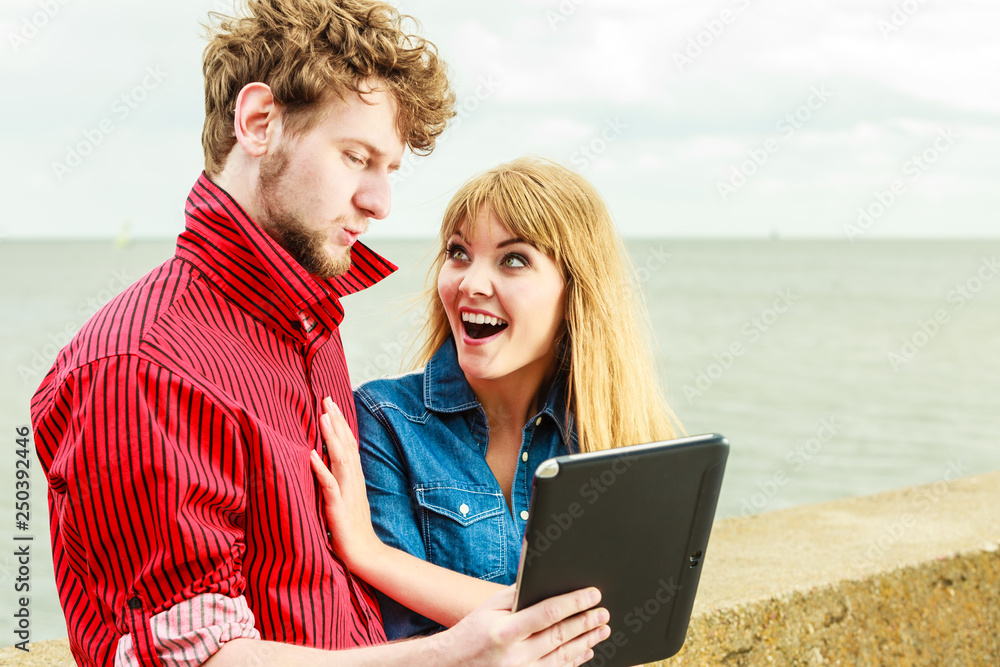 Young couple with tablet by seaside outdoor Young couple with tablet by seaside outdoor