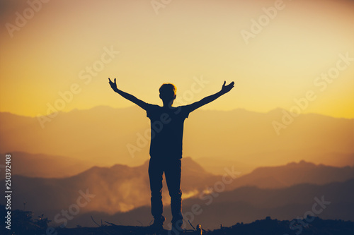 Man standing with lift hands for worshipping God at sunset background. christian silhouette concept.