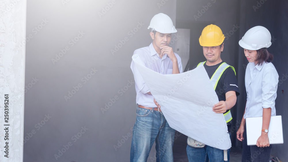 engineer working on checking progress of construction with blueprint at construction site engineer working on checking progress of construction with blueprint at construction site