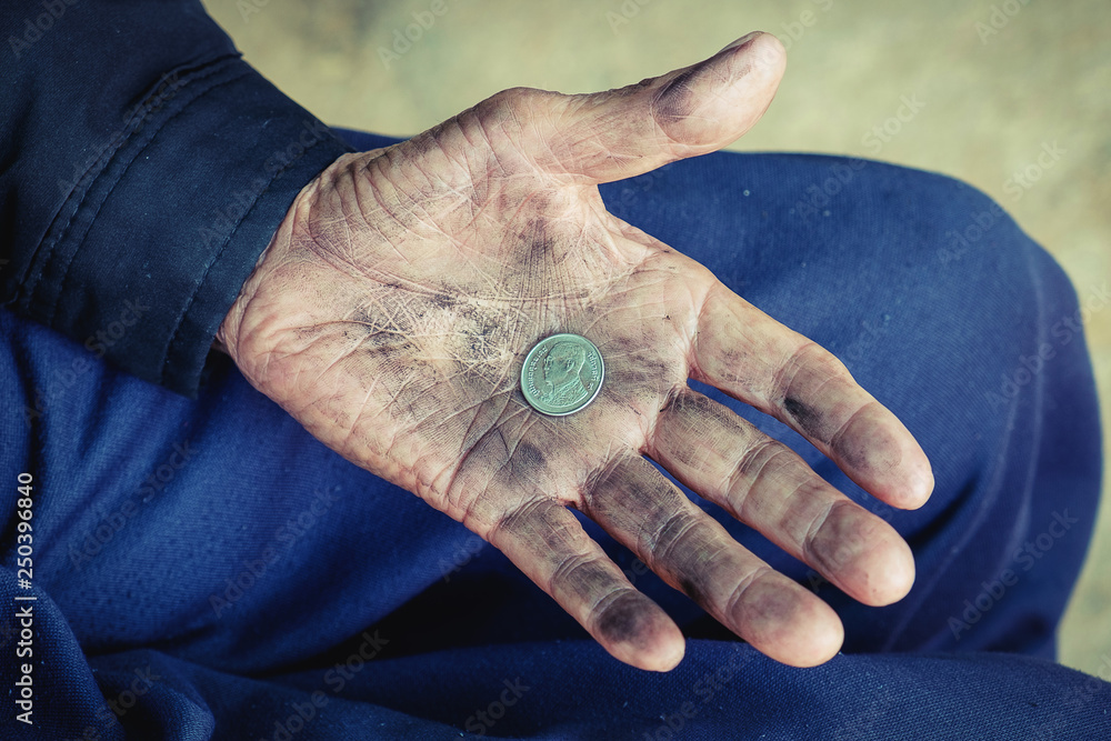 Obraz premium hand old man begging for money because of the hunger on the wood table. vintage tone