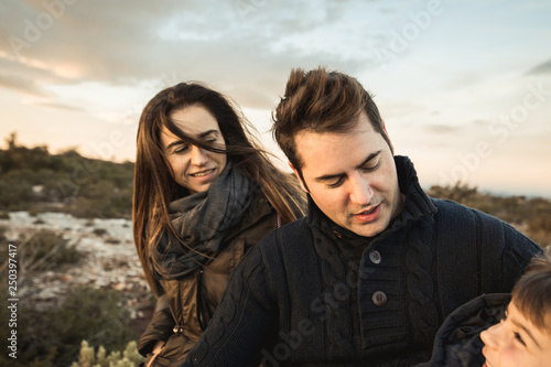 Portrait of a family smiling and happy in the countryside. Marriage with one child in the field