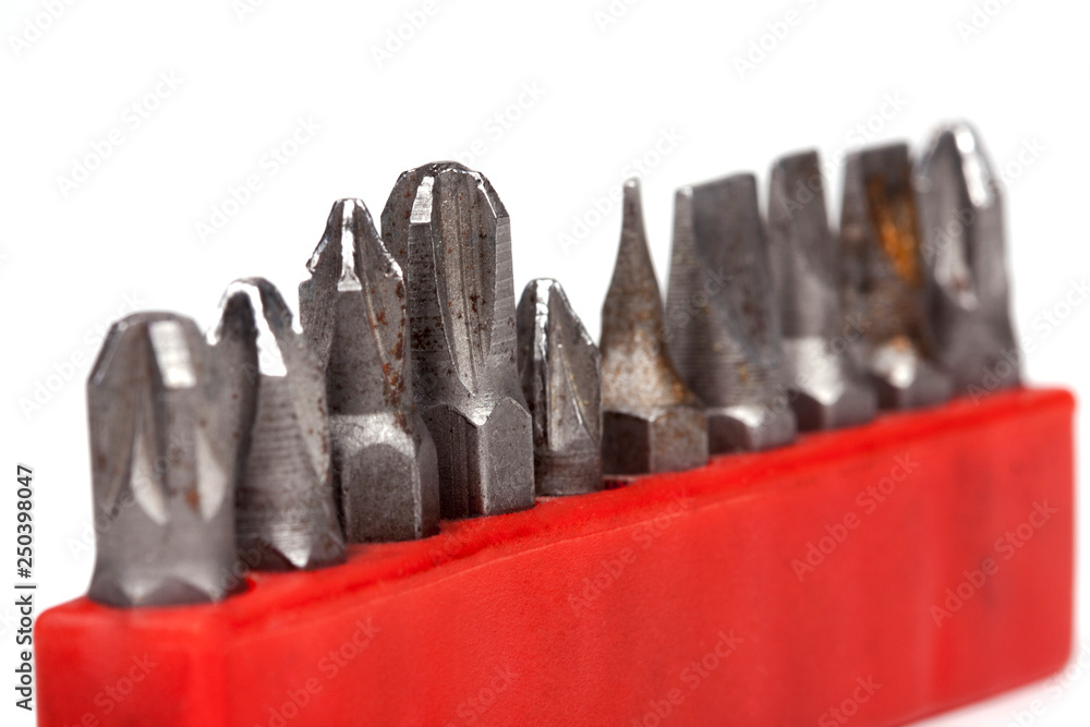 Collection of old rusty bit holders for a drill in a red case isolated on white background, macro, closeup Collection of old rusty bit holders for a drill in a red case isolated on white background, macro, closeup