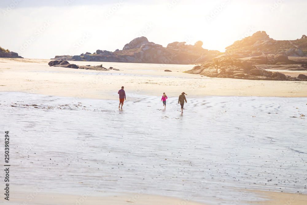Dad and two daughters running along the beach Dad and two daughters running along the beach