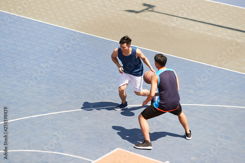 high angle view of young asian adults playing basketball outdoors © imtmphoto