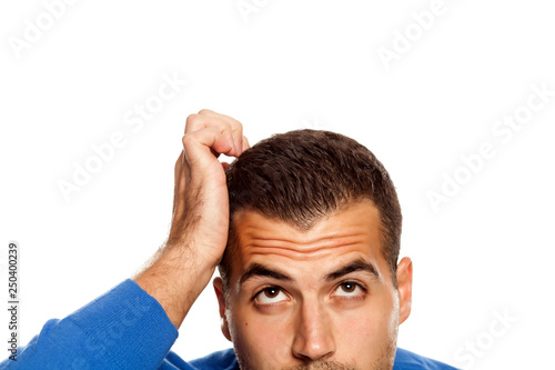 Tableau sur toile Half portrait of young confused man on white background
