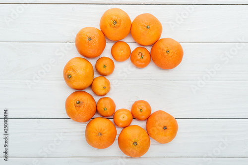 top view of letter C made of fresh tangerines on wooden white surface