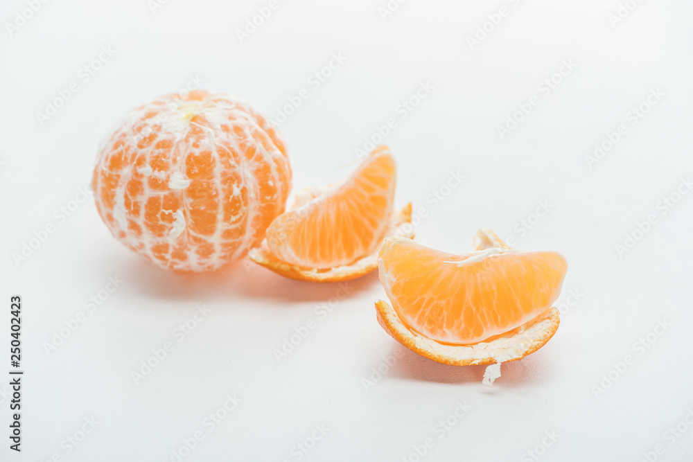 tangerine slices with peel and whole fruit on white background tangerine slices with peel and whole fruit on white background