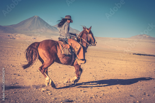 cowgirl woman riding a horse in the desert photo