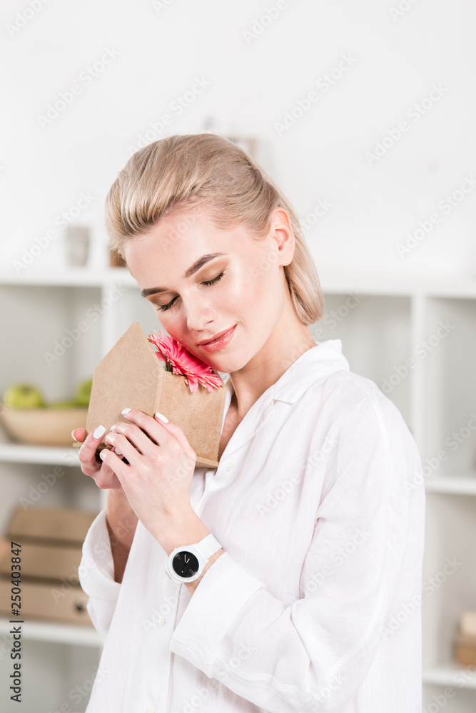 businesswoman embracing small cardboard house with flower in office, environmental saving concept businesswoman embracing small cardboard house with flower in office, environmental saving concept