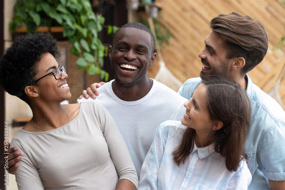 Fototapeta premium Black and caucasian mates embracing laughing posing for photo
