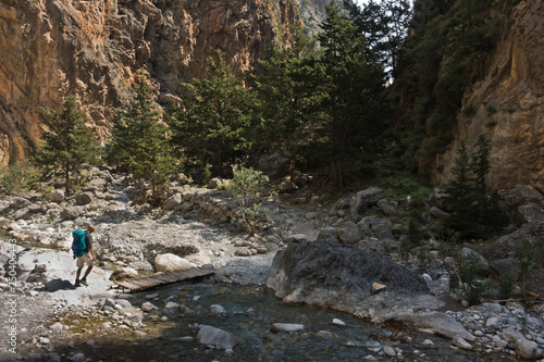 Crossing over mountain river at rocky terrain of Samaria gorge, south west part of Crete island, Greece