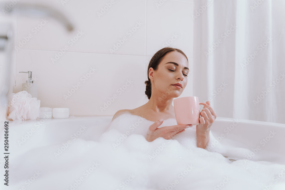 Nice delighted woman enjoying time in the bathroom Nice delighted woman enjoying time in the bathroom