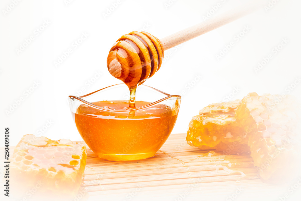 Honiglöffel mit Glasschälchen auf Bambusmatte Honiglöffel mit Glasschälchen auf Bambusmatte