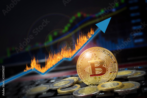 Bitcoin currency rising arrow price record highs on keyboard computer with golden bitcoin and other currencies.