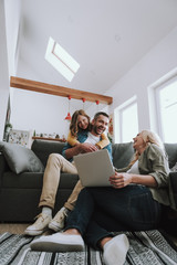 Happy family watching videos on laptop and laughing