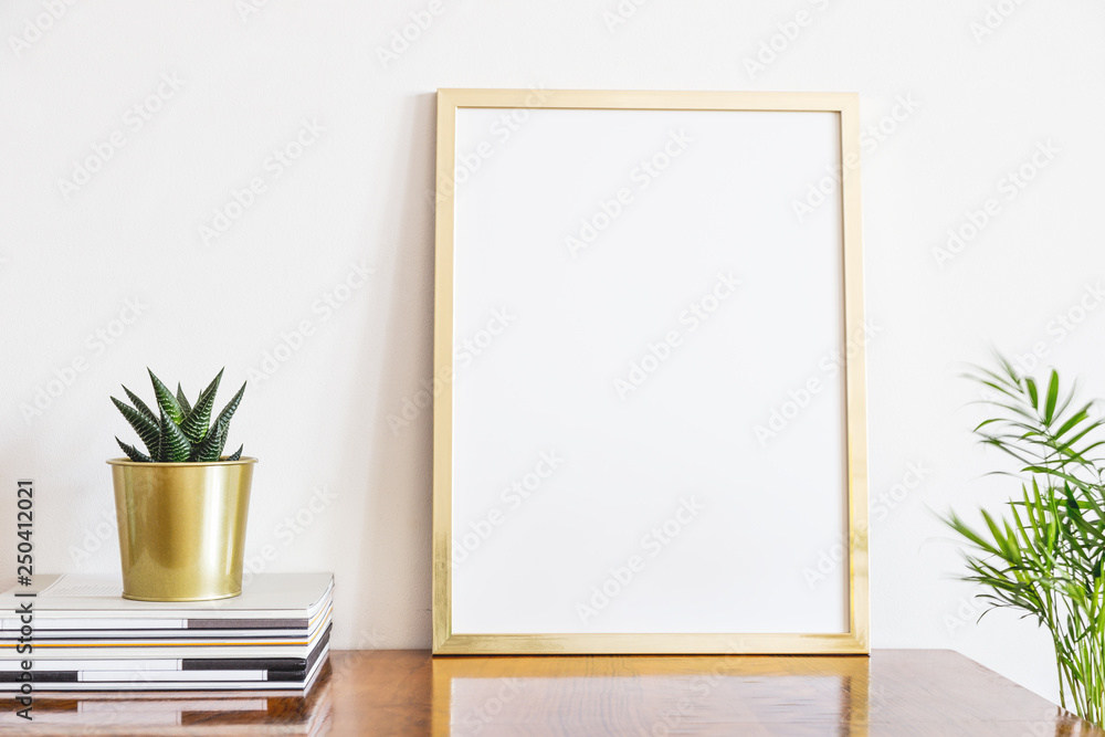 Bright interior detail with gold frame mock up and succulent plant in gold flower pot. Bright interior detail with gold frame mock up and succulent plant in gold flower pot.