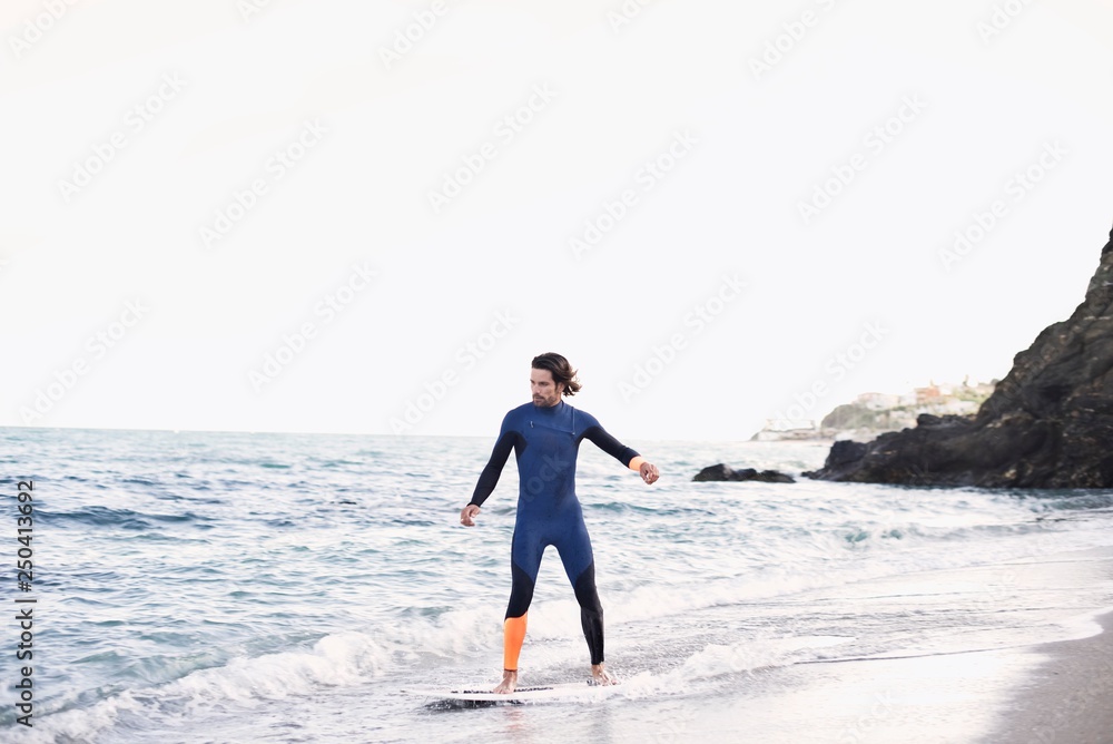 Caucasian man skim boarding at the beach Caucasian man skim boarding at the beach