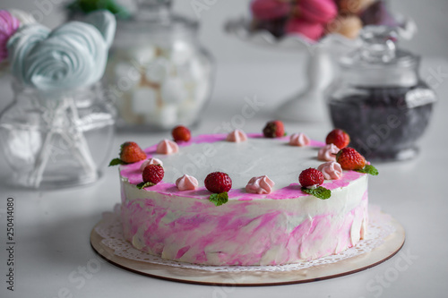 pink cake with berries on a white table