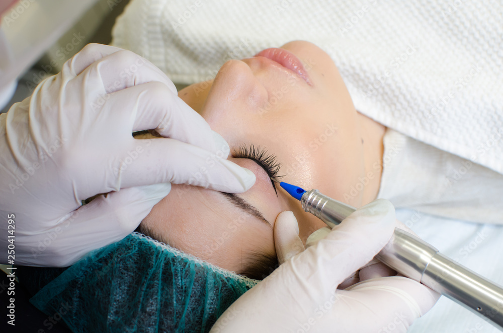 Permanent make-up tattoo. Cosmetologist applying permanent make up eyeliner, eyeliner tattoo procedure on young woman in beauty salon, extreme close up Permanent make-up tattoo. Cosmetologist applying permanent make up eyeliner, eyeliner tattoo procedure on young woman in beauty salon, extreme close up