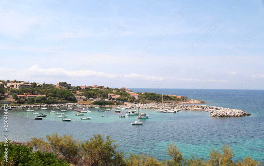 Small boats at anchor in the bay at Algajola on the northern coast of Corsica, France
