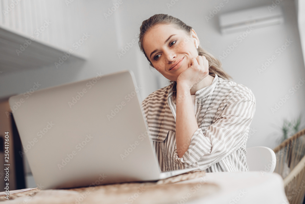 Cheerful female chatting on laptop at home Cheerful female chatting on laptop at home
