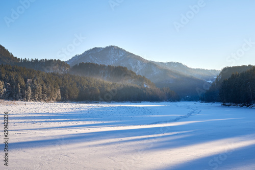 Majestic sunset in the winter mountains landscape. Dramatic sky. Altai region