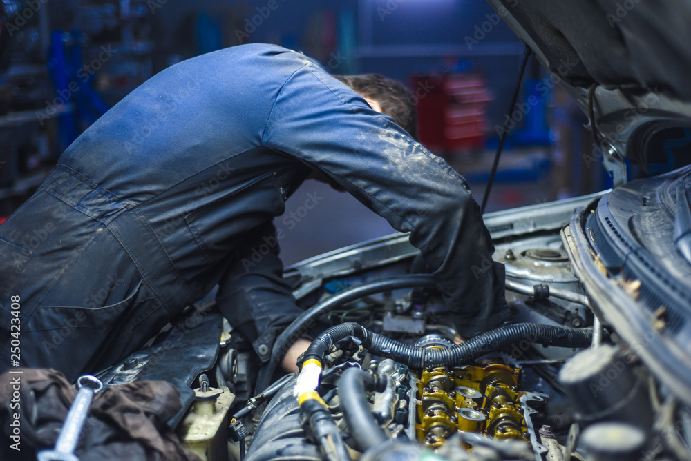 mechanic repairing a car engine mechanic repairing a car engine