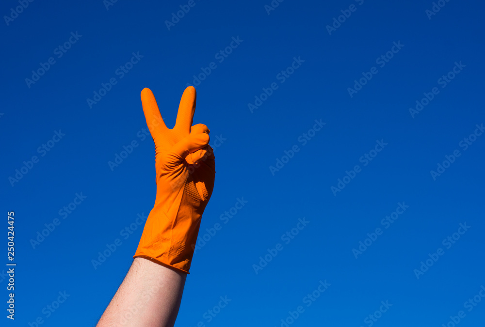 Hand in orazhevoy glove, a gesture against the blue sky. Hand in orazhevoy glove, a gesture against the blue sky.