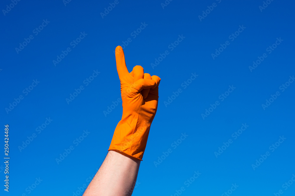 Hand in orazhevoy glove, a gesture against the blue sky. Hand in orazhevoy glove, a gesture against the blue sky.