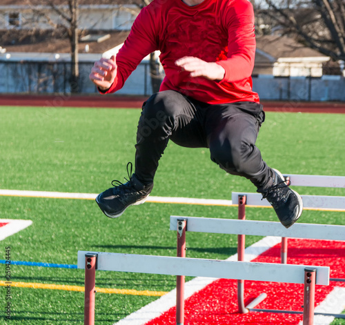 Runner jumping over hurdles for strngth and agility practice