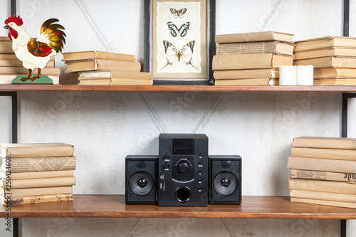 Compact music center in vintage residential loft interior on the shelf among books and accessories