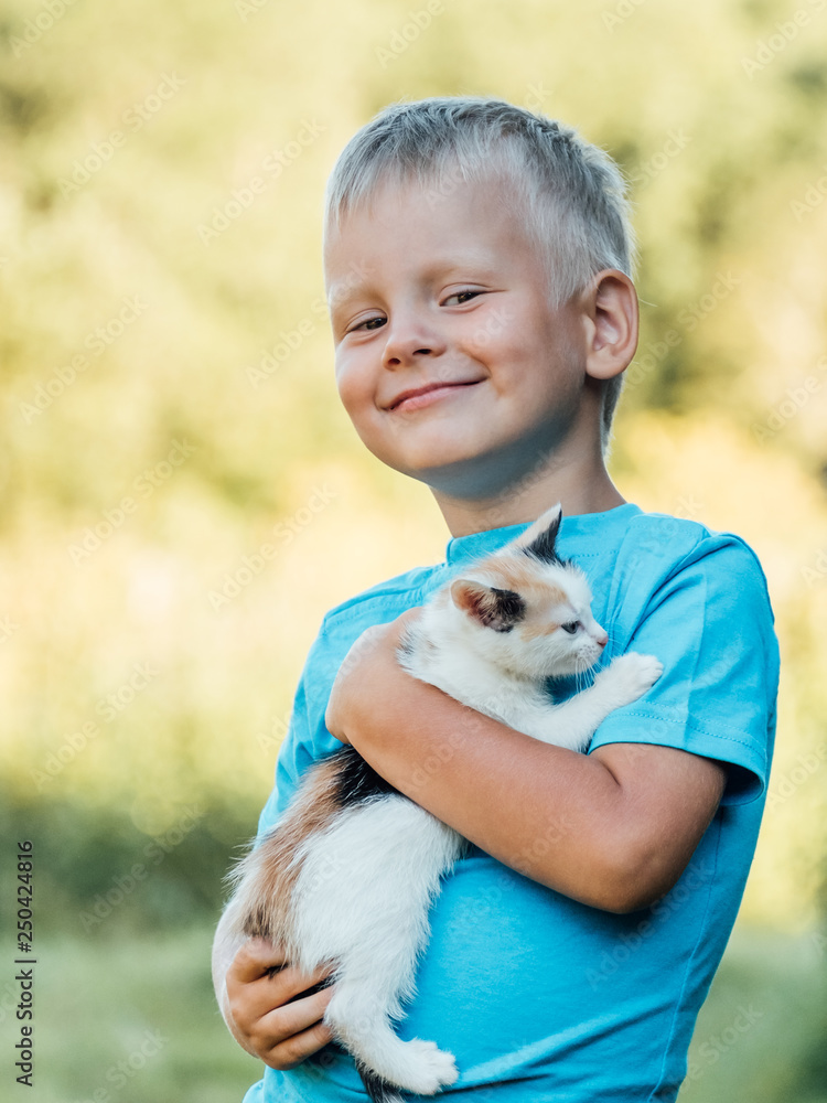 Little boy at countryside holding his lovely fluffy kitty cat Little boy at countryside holding his lovely fluffy kitty cat