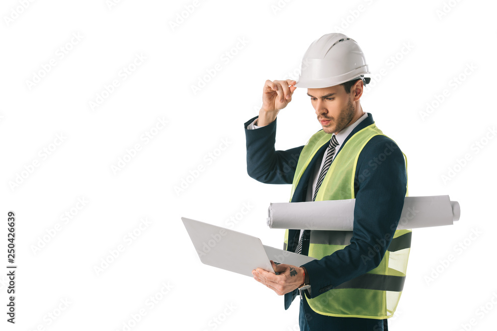 male engineer in hardhat and safety vest holding blueprint and using laptop, isolated on white male engineer in hardhat and safety vest holding blueprint and using laptop, isolated on white