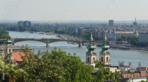 Aerial view of the Danube river, bridge, church and roofs in Budapest, sunny day, Hungary