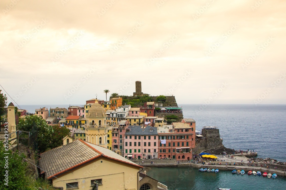 Obraz premium Beautiful small town of Vernazza in the Cinque Terre national Park. View on Castello Doria the old fortress and tower at the coastal hill of Vernazza. Beautiful evening sunset on Cinque Terre.