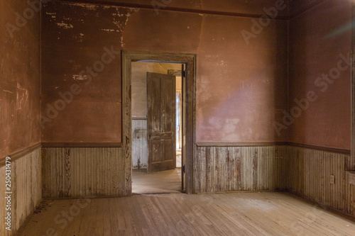 Looking through two doorways in a an old farmhouse with wainscoting photo