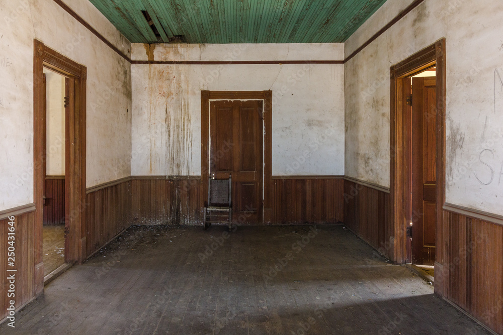 Three brown wooden doorways in an old farmhouse with wainscoting