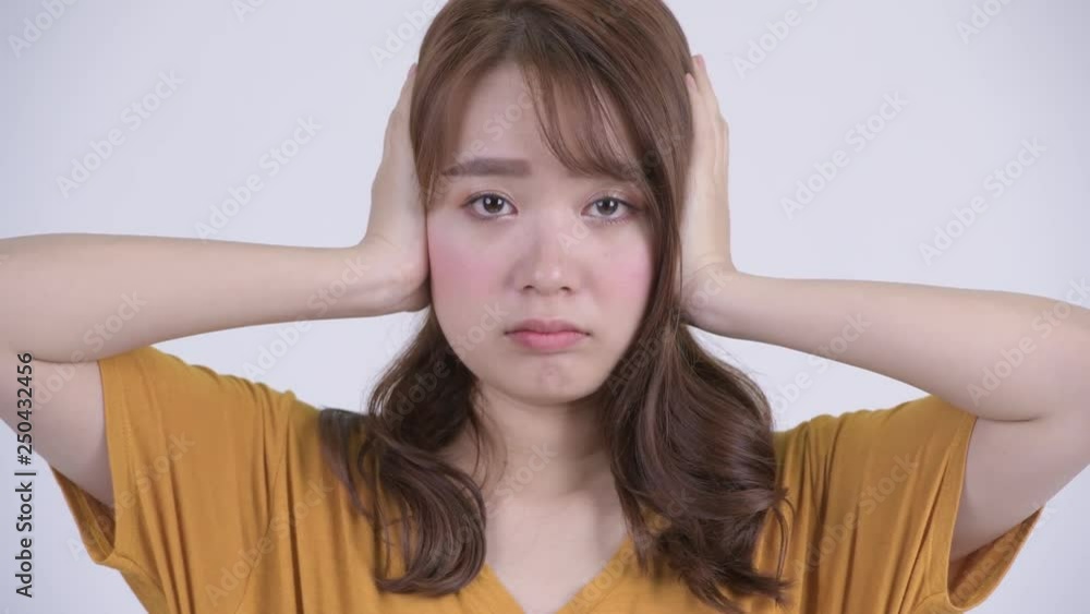 Face of young beautiful Asian woman covering ears as three wise monkeys concept Face of young beautiful Asian woman covering ears as three wise monkeys concept