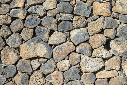 Stone wall made of volcanic rocks, background texture.