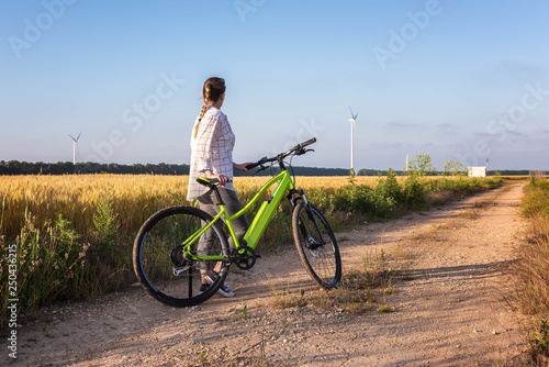Woman with a bike in the nature / Woman with a bicycle on a field path