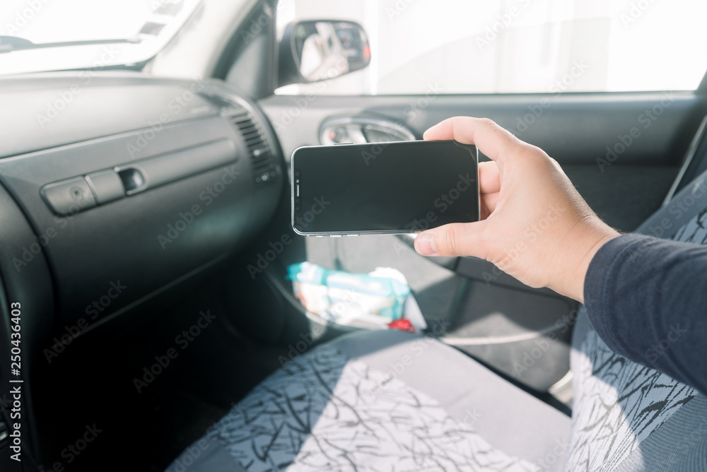 Closeup on hand holding smartphone for assistance, car communication gps navigation system background. Empty display ready for digital map assistant, modern electronic equipment technology device.